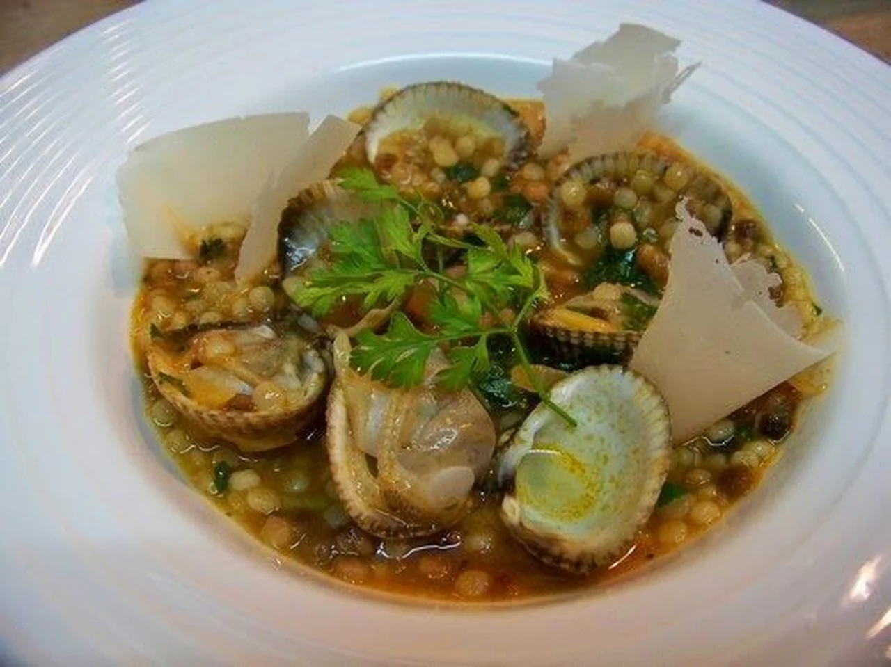 Fregola sardes aux coques et pétales de Parmesan