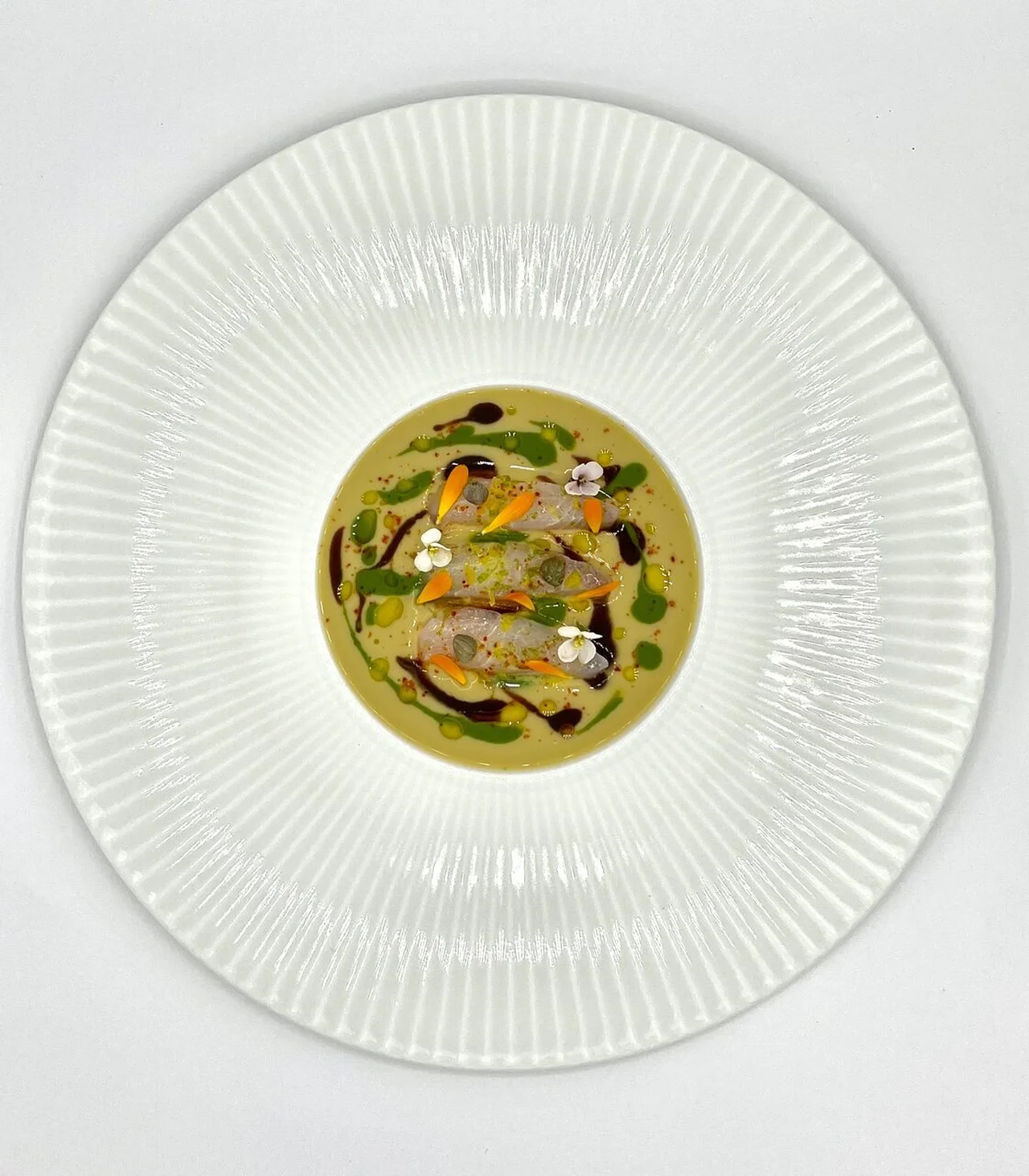 Daurade marinée, velours d'artichaut à l'ail noir et roquette