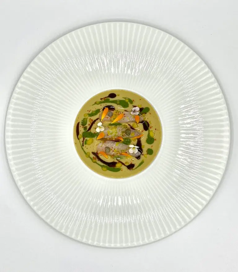 Daurade marinée, velours d'artichaut à l'ail noir et roquette
